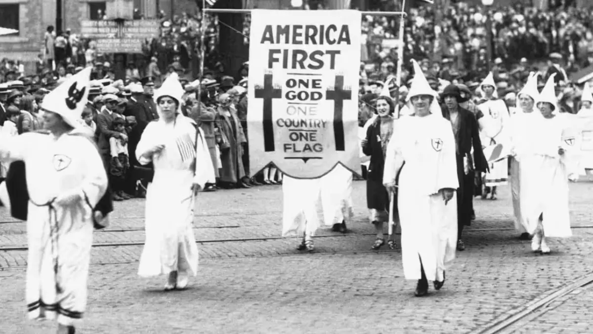 Klan members hold an 'America First' sign during a demonstration.