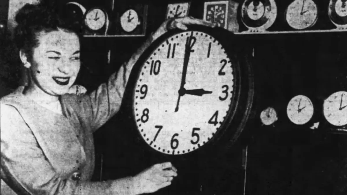 Photograph of a woman resetting a clock for Daylight Savings Time